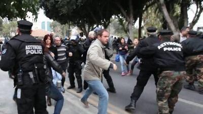 Employees of Laiki (Popular) Bank, the second largest on the island, clash with police as they demonstrate outside the House of Representatives in Nicosia.