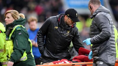 Manager Jurgen Klopp speaks with Salah as he is carried off the pitch on a stretcher. Laurence Griffiths / Getty Images