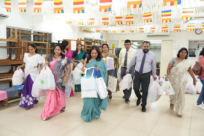 Staff at the Sri Lankan consulate in Dubai carry aid supplies donated by UAE residents for survivors of Cyclone Ditwah. Pawan Singh for The National