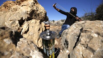 A Palestinian hurls stones at Israeli troops during a protest against land seizures in al-Mazraah al-Gharbiyah near Ramallah. AFP