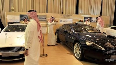 Saudi men shop for Aston Martins. Saudi Arabia emerges as home to the largest numbers of hyper-wealthy outside of the United States and Germany. AFP PHOTO/AMER HILABI