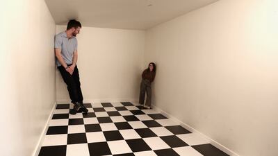 Visitors experience an illusion room at the World Of Mind museum in Brussels. Reuters