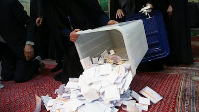 Poll workers empty full ballot boxes after the parliamentary election voting time ended in Tehran. REUTERS