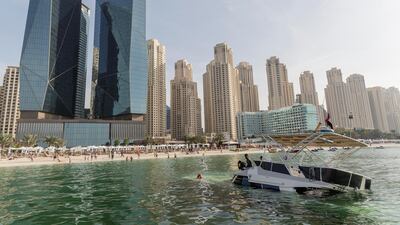 A sunken yacht being salvaged by its owner, Mohamed Irfan, and some volunteer divers off the beach on JBR. Antonie Robertson/The National