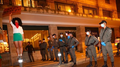 A demonstrator holds a sign in Hebrew that reads "just not Bibi," in front of a line of police officers during a protest against Israeli Prime Minister Benjamin Netanyahu in Jerusalem. AP Photo