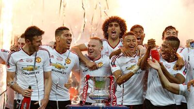 Manchester United’s players celebrate with the trophy after their victory after extra time in the English FA Cup final football match between Crystal Palace and Manchester United at Wembley stadium in London on May 21, 2016. Manchester United won the game 2-1, after extra time. Ian Kington / AFP