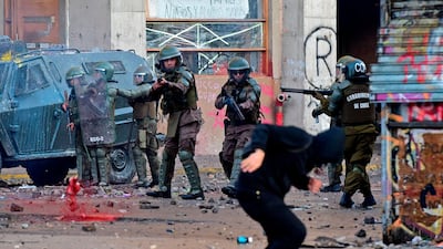 Riot police aim at a demonstrator during a protest against the government and to commemorate the first anniversary of the death of Mapuche indigenous leader Camilo Castrillanca -killed in a police operation- in Santiago. AFP