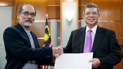 Mohd Mazarin Bin Ismail, left, chairman of Boycott, Divestment and Sanctions (BDS) Malaysia, hands over a memorandum to Malaysia Foreign Minister Saifuddin Abdullah before a press conference in Putrajaya, Malaysia. AP