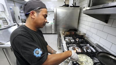 Chef Marcelo Perez Jr cooks up a meal at Cycle Hub, which already discloses the calorie content of their food to customers. Chris Whiteoak / The National