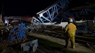A rescue worker inspects the scene after ab elevated road collapsed, killing at least one person in Bangkok. AFP
