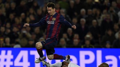 Barcelona's Lionel Messi jumps over Manchester City's Fernandinho during their Champions League match on Wednesday night. Lluis Gene / AFP