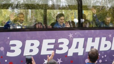 Hazza Al Mansouri, Oleg Skripochka and Jessica Meir wave to crowds as they leave for the launch pad. EPA