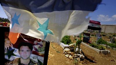 In a Tartus cemetery, Syrian flags flutter above dozens of graves, many bearing photos of the deceased. Joseph Eid/AFP Photo