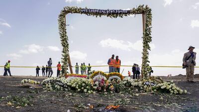 Candles burn before a flower-adorned memorial arch erected at the site of the Ethiopian Airlines Flight ET302 crash in Ejere, Ethiopia. Getty Images