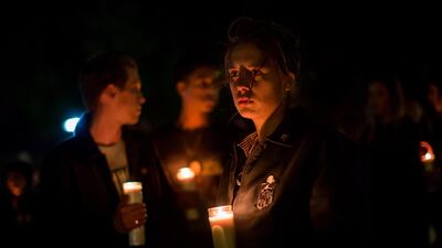 People hold candles during a vigil to pay tribute to the victims. AFP
