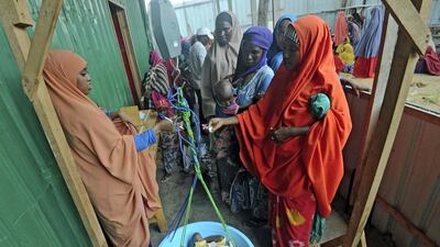 Displaced Somali women weighing their malnourished children as they try to receive medical treatment on the outskirts of Mogadishu. Mohamed Abdiwahab / AFP