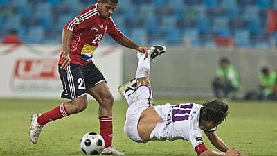 Al Ahli's Ali Hussain, left, sends Al Ain captain Jorge Valdivia flying on Wednesday night.