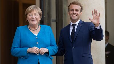 French President Emmanuel Macron welcomes German Chancellor Angela Merkel to the Elysee Palace in Paris on Thursday. EPA
