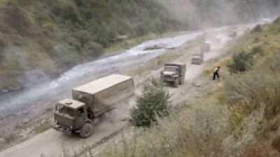 A column of a dozen Russian military trucks move along the road near Verkhny Zaramag in North Ossetia after crossing the border into Russia from Georgia earlier today.