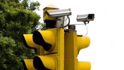Closed-circuit television cameras mounted on a traffic light record New Delhi.