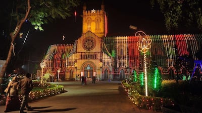 India: Indian residents walk in front of the All Saints Cathedral, decorated with Christmas lights, ahead of Christmas celebrations in Allahabad. AFP Photo/Sanjay Kanojia