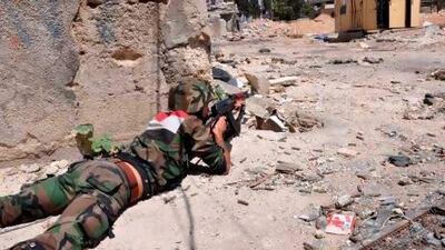 A member of the Syrian armed forces takes position during a patrol near the Al Manashir roundabout in Jobar, in the outskirts of Damascus.
