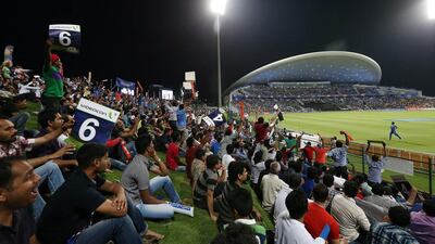 Fans watch the IPL opening match between Mumbai Indians vs Kolkata Knight Riders at Zayed Cricket Stadium in Abu Dhabi. Pawan Singh / The National