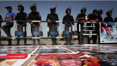 Egyptian riot police stand guard last month near pictures of protesters killed during the 2011 uprising that ousted president Hosni Mubarak.