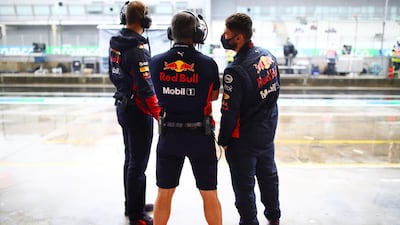 Red Bull Racing team members look at the pitlane. Getty