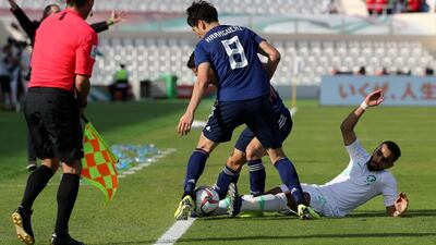 Saudi Arabia defender Mohammed Al-Burayk, right, falls after a challenge from Japan's midfielder Genki Haraguchi. AFP