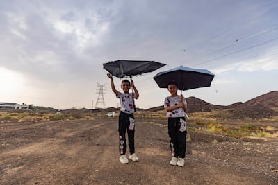Two young children were well prepared for the wet weather in Hatta. Antonie Robertson / The National