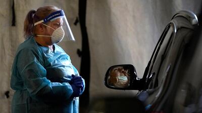 A healthcare worker watches as a patient uses a swab at a mobile testing location for Covid-19, in Auburn, Maine. More than 14,000 Mainers have been diagnosed with the disease and 239 have died. AP