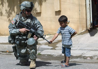 A US soldier chats with an Iraqi boy in the northern Al Sukkar neighborhood of Mosul. AFP