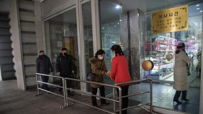 Shoppers receive hand sanitizer as they enter the Pyongyang Department Store No. 1, in Pyongyang. AFP