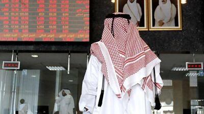 A Qatari keeps an eye on the big board of trading activity at the Doha Securities Exchange. Ryan Carter / The National