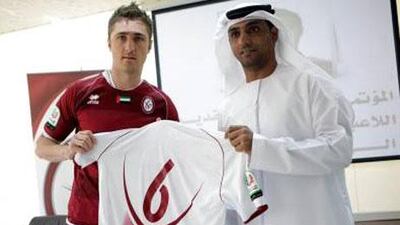 Dino Djulbic, right, displays his new kit top with Abdullah Salem, the Al Wahda team manager.