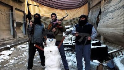 Members of the Free Syrian Army pose with their weapons and a snowman at the Jouret Al Shayah area in Homs. The storm-force winds, torrential rain and snow that blew down from Lebanon has resulted in flooded homes and overflowing sewers.