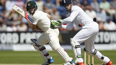 Australia’s Chris Rogers, left, plays a shot for four runs watched by England’s wicketkeeper Jos Buttler during play on Day 2 of the opening Ashes cricket Test match at the Swalec Stadium in Cardiff, south Wales, on July 9, 2015. England were bowled out for 430. AFP PHOTO / IAN KINGTON