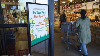 A social distancing sign is displayed at the entrance to a supermarket in Paramus, New Jersey, US. Bloomberg