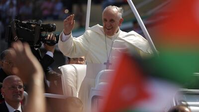 Pope Francis waves to pilgrims upon his arrival at the Amman stadium on Saturday. Patrick Baz / AFP