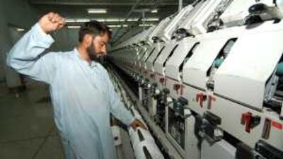 A worker adjusts yarn at a modern textile unit at the Gadoon Textile Industries factory.