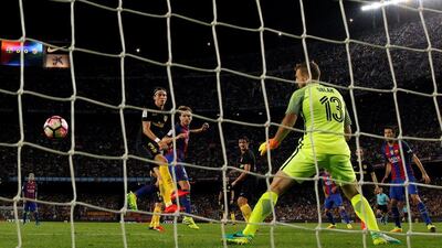 Barcelona’s Ivan Rakitic heads the ball to score a goal against Atletico Madrid’s Filipe Luis and goalkeeper Jan Oblak. Albert Gea / Reuters