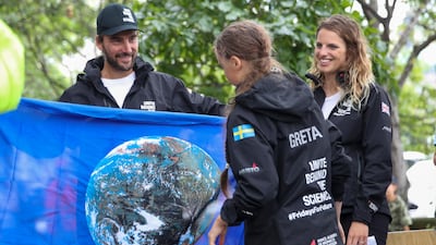 Boris Herrmann, left, the captain of the zero-emissions yacht, the Malizia II, presents Greta Thunberg, a 16-year-old Swedish climate activist, with a flag with an image of the earth after they arrived in New York, Wednesday, August 28, 2019, in New York. AP Photo/Mary Altaffer