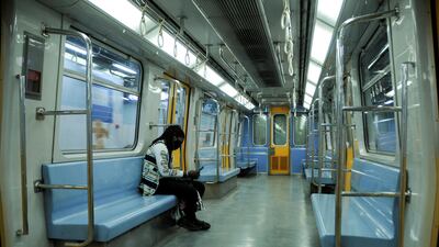 A woman wearing a protective face mask sits inside an empty metro train, as she travels on a line Shubra Al Khaimah to Tahrir Square, before the start of a night-time curfew amid concerns over the spread of the coronavirus disease, on the outskirts of Cairo. Reuters