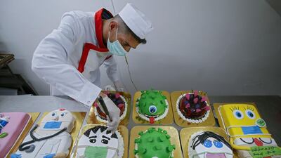 A Palestinian baker puts the final touches on coronavirus-themed cakes at his bakery in Khan Yunis in the Gaza Strip. AFP