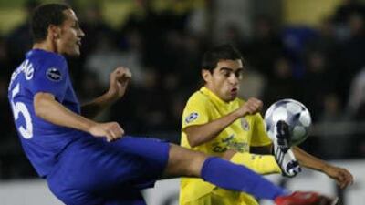 The Manchester United defender Rio Ferdinand, left, kicks the ball past Ariel Ibagaza of Villarreal.