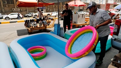 A shopkeeper puts out children's inflatable tubs for sale on a street in Baghdad.