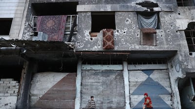 Syrian children play next to a destroyed building in the rebel-held town of Douma, on the eastern outskirts of the capital Damascus. Abd Doumany / AFP