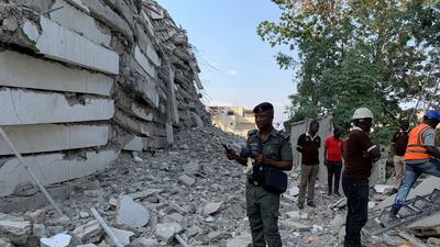 A policeman stands by the debris of the collapsed building in Ikoyi, Lagos. Reuters