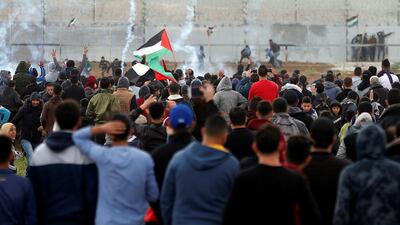 Palestinians gather as tear gas is fired by Israeli forces during a protest. Reuters